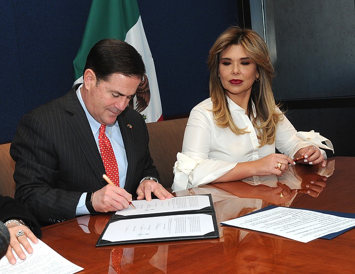 Gov. Doug Ducey signing pact. (Howard Fischer/Capital News Service)