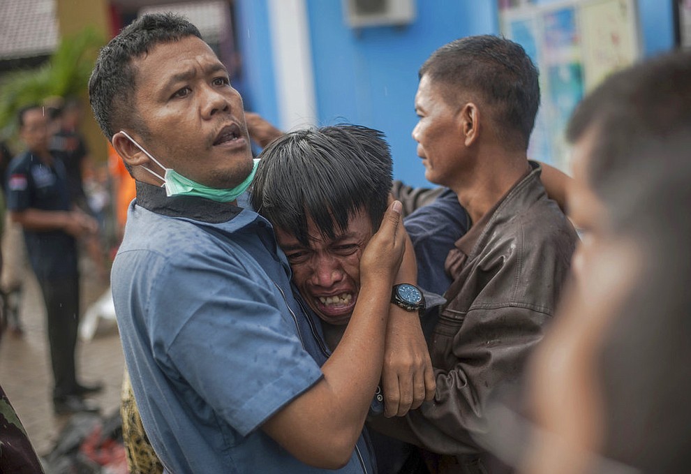 A man reacts after identifying his relative among the bodies of tsunami victims in Carita, Indonesia, Sunday, Dec. 23, 2018. The tsunami occurred after the eruption of a volcano around Indonesia's Sunda Strait during a busy holiday weekend, sending water crashing ashore and sweeping away hotels, hundreds of houses and people attending a beach concert. (AP Photo/Fauzy Chaniago)