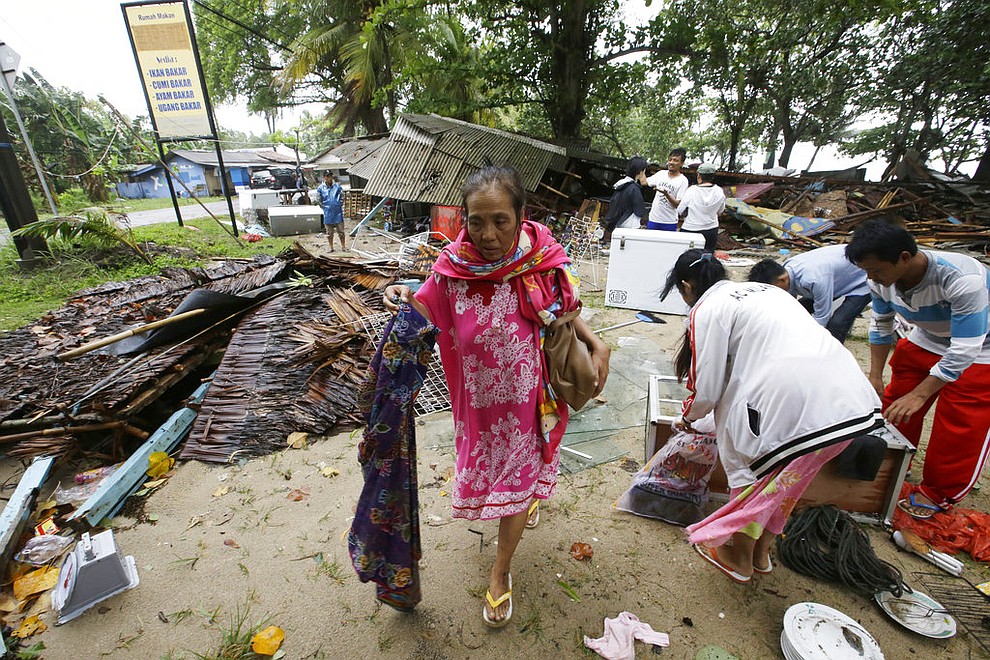 A women inspects her house which was damaged by a tsunami, in Carita, Indonesia, Sunday, Dec. 23, 2018. The tsunami occurred after the eruption of a volcano around Indonesia's Sunda Strait during a busy holiday weekend, sending water crashing ashore and sweeping away hotels, hundreds of houses and people attending a beach concert. (AP Photo/Achmad Ibrahim)