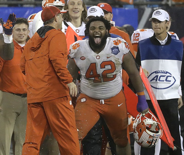 In this Saturday, Dec. 1, 2018, file photo, Clemson’s Christian Wilkins (42) laughs with head coach Dabo Swinney in the closing seconds against Pittsburgh in Charlotte, N.C. (Chuck Burton/AP, file)