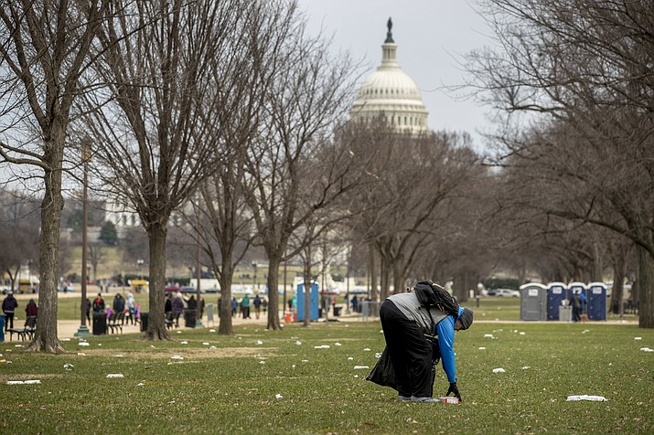 The Capitol building is visible as a man who declined to give his name picks up garbage during a partial government shutdown on the National Mall in Washington, Tuesday, Dec. 25, 2018. (Andrew Harnik/AP)