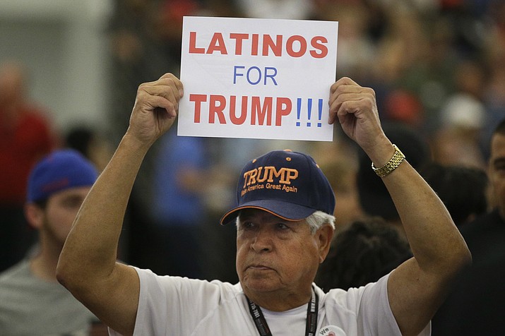 In this May 25, 2016, file photo, a man holds up a sign for then-Republican presidential candidate Donald Trump before the start of a rally at the Anaheim Convention Center, Wednesday, May 25, 2016, in Anaheim, Calif. Republicans are holding onto a steady share of the Latino vote in the Trump era. With a president who targets immigrants from Latin America, some analysts predicted a Latino backlash against the GOP. But it hasn’t happened. Data from AP’s VoteCast survey suggests Republicans are holding on to support from Latino evangelicals and veterans. (Jae C. Hong/AP, File)