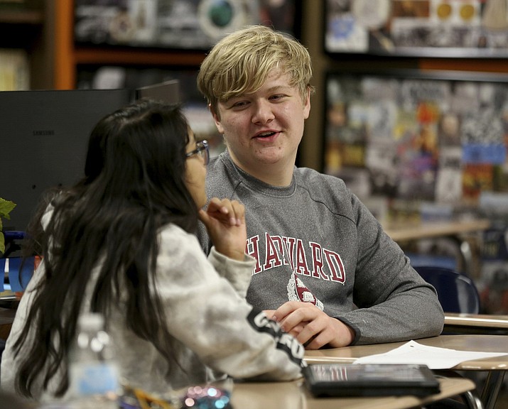 Government class students Alejandra Corral, left, and Braxton Moral work on calculating the estimated cost of living expenses as part of a talk about students who graduate high school making on average more money than non-graduates, at Ulysses High School in Ulysses, Kan., on Wednesday, Dec. 12, 2018. (Sandra J. Milburn/The Hutchinson News via AP)