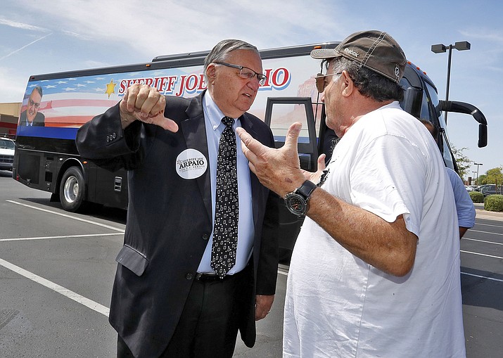 U.S. Senate candidate and former Maricopa County Sheriff Joe Arpaio talks Aug. 23 with a voter at a campaign stop in Scottsdale. Fresh off his pardon, an emboldened Arpaio tried to mount a comeback by running for the U.S. Senate. (Matt York/AP, File)