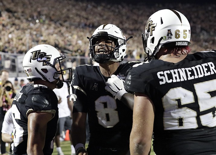 Central Florida quarterback Darriel Mack Jr. (8) celebrates with teammates including offensive lineman Cole Schneider (65) after scoring the go ahead touchdown against Memphis during the second half of the American Athletic Conference championship NCAA college football game, Saturday, Dec. 1, 2018, in Orlando, Fla. (John Raoux/AP)