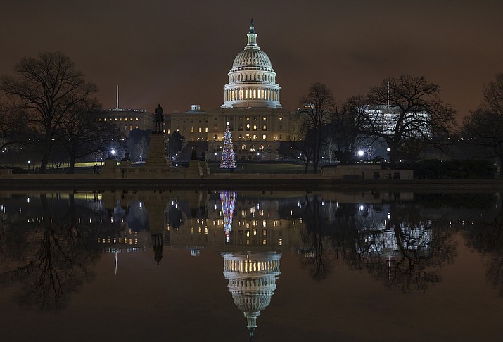 The Capitol is mirrored in the Reflecting Pool in Washington, as a partial government shutdown heads into a second week, Friday night, Dec. 28, 2018. (J. Scott Applewhite/AP)
