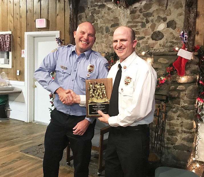 Williams Volunteer Fire Department selected a new fire chief and assistant chief during its Dec. 5 meeting. Chase Pearson (right) was recognized for his five years as fire chief during the Dec. 8 Williams Fire Department Christmas party. Kevin Shulte (left) was selected by fire department members as the new chief. Don Mackay was selected as assistant fire chief replacing John Moede. Ryan Kopicky and Cameron Maebe were selected as captains for the department. (Loretta Yerian/WGCN)