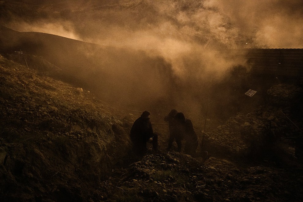 Migrants run as tear gas is thrown by U.S. Border Protection officers to the Mexican side of the border fence after they climbed the fence to get to San Diego, Calif., from Tijuana, Mexico, Tuesday, Jan. 1, 2019. Discouraged by the long wait to apply for asylum through official ports of entry, many migrants from recent caravans are choosing to cross the U.S. border wall and hand themselves in to border patrol agents. (AP Photo/Daniel Ochoa de Olza)