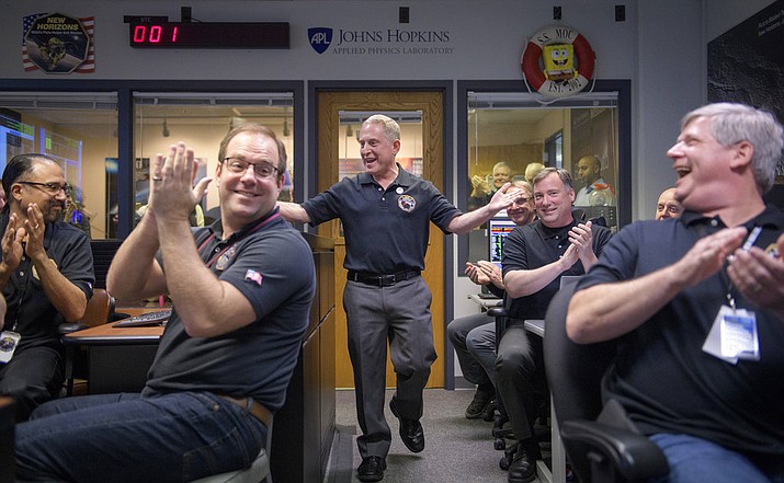 New Horizons principal investigator Alan Stern, center, of the Southwest Research Institute in Boulder, Colo., celebrates with other mission team members after they received signals from the New Horizons spacecraft that it is healthy and collected data during the flyby of Ultima Thule, Tuesday, Jan. 1, 2019, at the Mission Operations Center at the APL in Laurel, Md. (Bill Ingalls/NASA via AP)