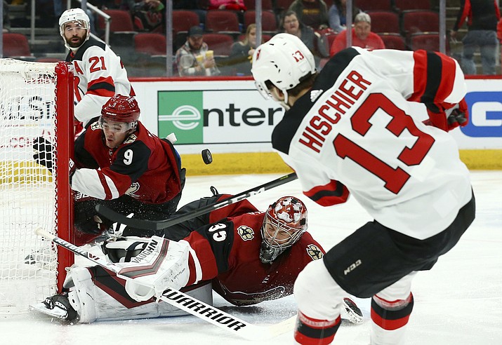 New Jersey Devils center Nico Hischier (13) scores a goal as he gets the puck past Arizona Coyotes goaltender Darcy Kuemper (35) and center Clayton Keller (9), as Devils right wing Kyle Palmieri (21) watches during the first period of an NHL hockey game Friday, Jan. 4, 2019, in Glendale, Ariz. The puck did not actually go into the net but it was ruled a goal due to Coyotes center Clayton Keller moving the net out of place; officials said the puck would have gone in for the score. (Ross D. Franklin/AP)