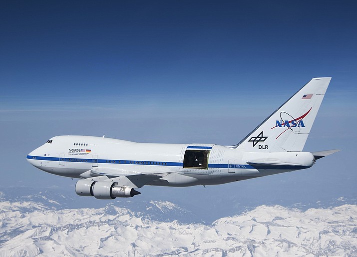 This undated photo provided by NASA shows SOFIA over the snow-covered Sierra Nevada mountains with its telescope door open during a test flight. The world's largest airborne observatory was supposed to be parked in Seattle this week, so thousands of scientists attending the "Super Bowl of Astronomy" could behold this marvel: a Boeing 747, like this one shown, for example, outfitted with a massive telescope used to study the fundamental mysteries of the universe. (Jim Ross/NASA via AP)