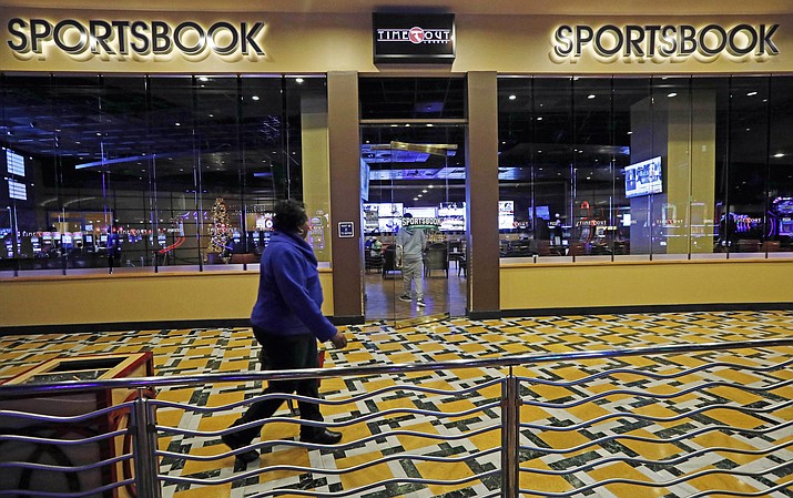 A In this Dec. 18, 2018 photo, a woman walks by the Time Out Lounge at the Pearl River Resort, in Philadelphia, Mississippi. The sports book owned by the Mississippi Band of Choctaw Indians is the first to open on tribal lands outside of Nevada following a U.S. Supreme Court ruling earlier this year, a no-brainer business decision given the sports fans among its gambling clientele. (AP Photo/Rogelio V. Solis)