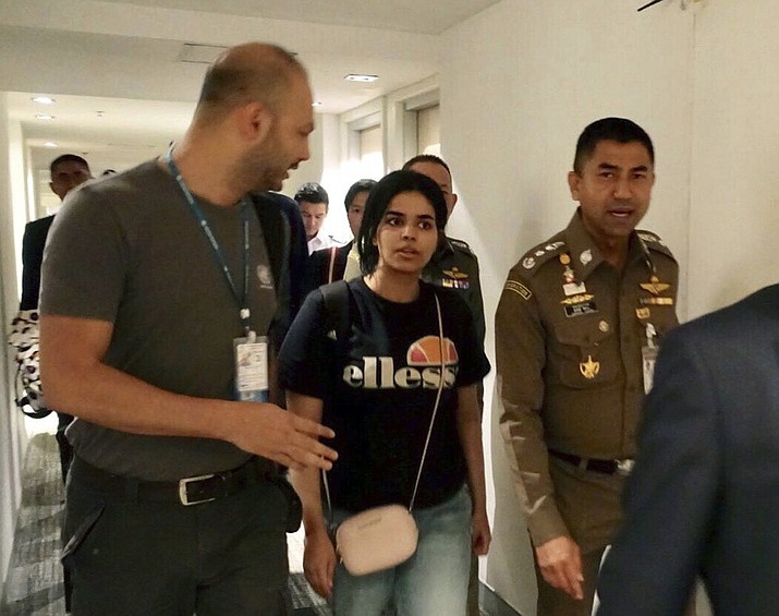In this Jan. 7, 2019, file photo released by the Immigration Police, Chief of Immigration Police Maj. Gen. Surachate Hakparn, right, walks with Saudi woman Rahaf Mohammed Alqunun before leaving the Suvarnabhumi Airport in Bangkok, Thailand. Australia says it is considering granting the Saudi who fled from her family refugee resettlement based on referral by the U.N. (Immigration police via AP, File)