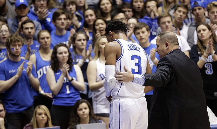 Duke's Tre Jones (3) is escorted from the court following an injury during the first half of an NCAA college basketball game against Syracuse in Durham, N.C., Monday, Jan. 14, 2019. No. 1-for-now Duke will have to figure out how to play without perhaps its most irreplaceable player now that point guard Tre Jones is out indefinitely with a shoulder injury. (Gerry Broome/AP)