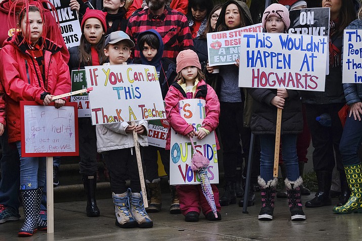 Elementary students, from right, Sawyer Mack is joined by his sisters, Capri and Kaya in support of a teachers strike in front of Hamilton High School in Los Angeles on Wed. Jan. 16, 2019.  (AP Photo/Richard Vogel)