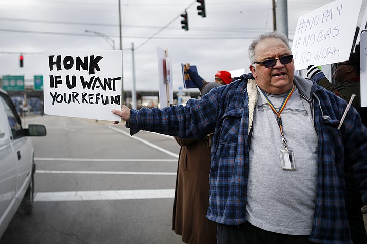 Will Kohler, an IRS tax examiner, holds a protest sign as union members and other federal employees rally Jan. 10, 2019, to call for an end to the partial government shutdown outside the IRS site, in Covington, Ky. (John Minchillo/AP)