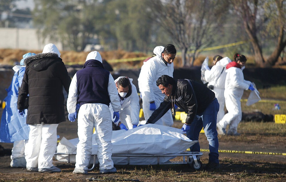 Forensic experts working in the area an oil pipeline explosion in Tlahuelilpan, Hidalgo state, Mexico, Saturday, Jan. 19, 2019. A massive fireball that engulfed people scooping up fuel spilling from a pipeline ruptured by thieves in central Mexico killed dozens of people and badly burned many more. (AP Photo/Claudio Cruz)