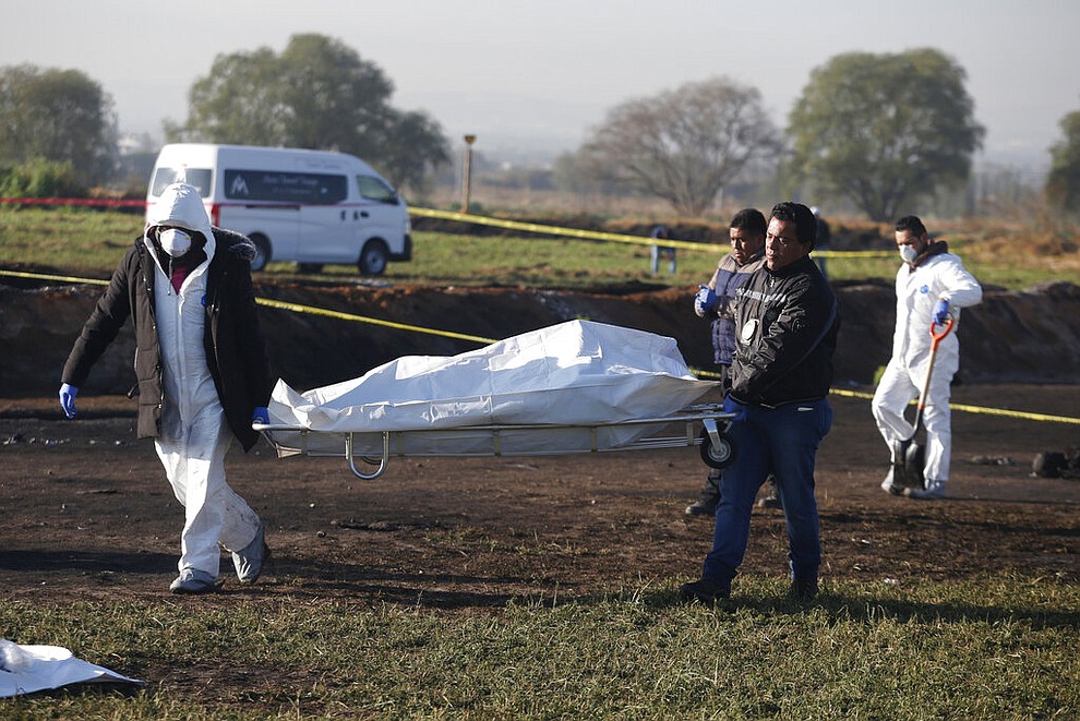 Forensic experts working in the area an oil pipeline explosion in Tlahuelilpan, Hidalgo state, Mexico, Saturday, Jan. 19, 2019. A massive fireball that engulfed people scooping up fuel spilling from a pipeline ruptured by thieves in central Mexico killed dozens of people and badly burned many more. (AP Photo/Claudio Cruz)