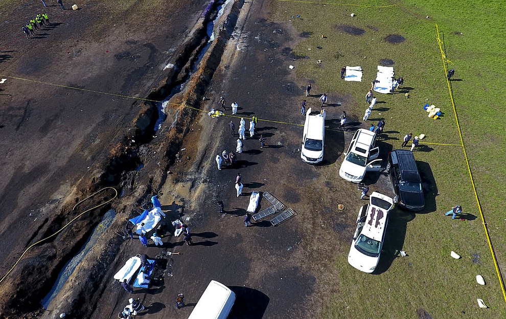 Forensic experts work the area an oil pipeline explosion in Tlahuelilpan, Hidalgo state, Mexico, Saturday, Jan. 19, 2019. A massive fireball that engulfed people scooping up fuel spilling from a pipeline ruptured by thieves in central Mexico killed dozens of people and badly burned many more. (AP Photo/Claudio Cruz)