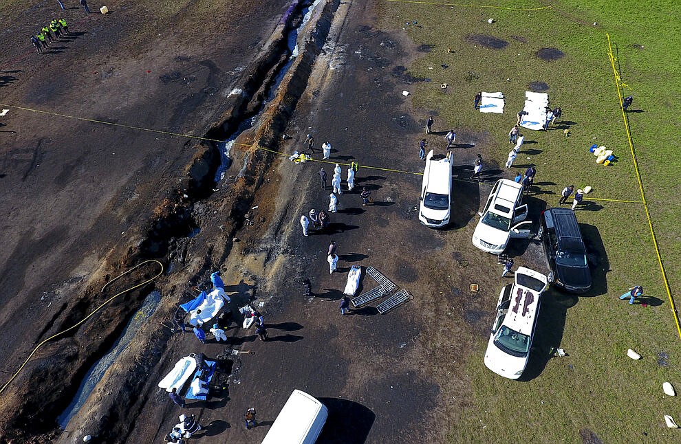 Forensic experts work the area an oil pipeline explosion in Tlahuelilpan, Hidalgo state, Mexico, Saturday, Jan. 19, 2019. A massive fireball that engulfed people scooping up fuel spilling from a pipeline ruptured by thieves in central Mexico killed dozens of people and badly burned many more. (AP Photo/Claudio Cruz)