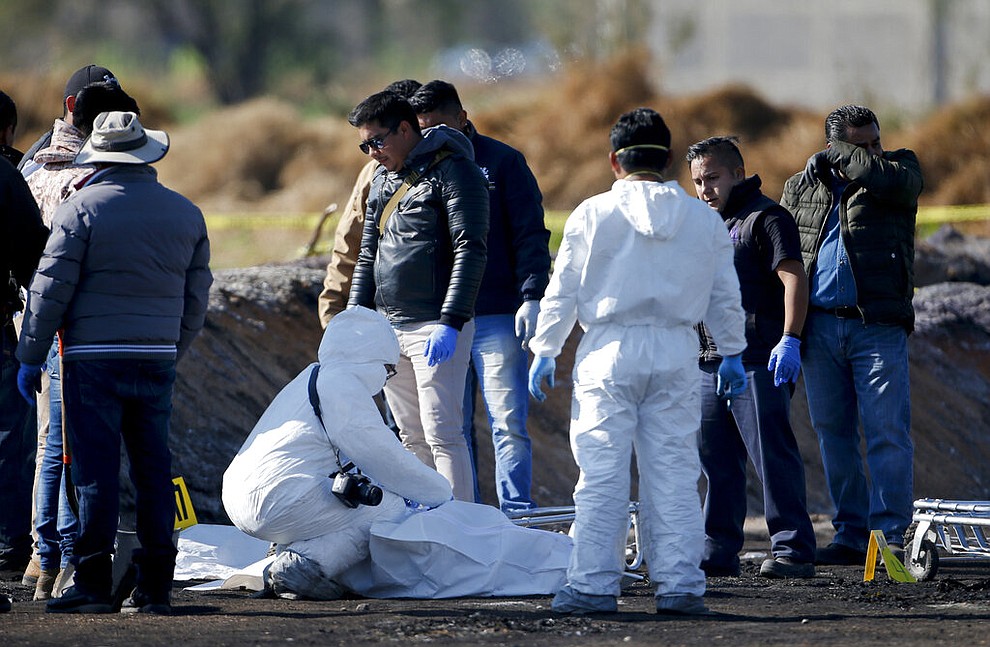 Forensic experts working in the area an oil pipeline explosion in Tlahuelilpan, Hidalgo state, Mexico, Saturday, Jan. 19, 2019. A massive fireball that engulfed people scooping up fuel spilling from a pipeline ruptured by thieves in central Mexico killed dozens of people and badly burned many more. (AP Photo/Claudio Cruz)