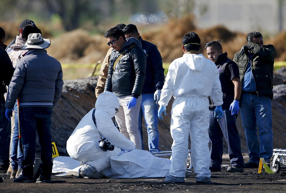 Forensic experts working in the area an oil pipeline explosion in Tlahuelilpan, Hidalgo state, Mexico, Saturday, Jan. 19, 2019. A massive fireball that engulfed people scooping up fuel spilling from a pipeline ruptured by thieves in central Mexico killed dozens of people and badly burned many more. (AP Photo/Claudio Cruz)