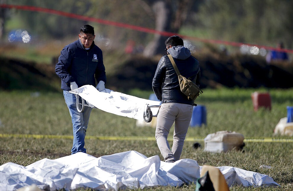 Forensic experts working in the area an oil pipeline explosion in Tlahuelilpan, Hidalgo state, Mexico, Saturday, Jan. 19, 2019. A massive fireball that engulfed people scooping up fuel spilling from a pipeline ruptured by thieves in central Mexico killed dozens of people and badly burned many more. (AP Photo/Claudio Cruz)