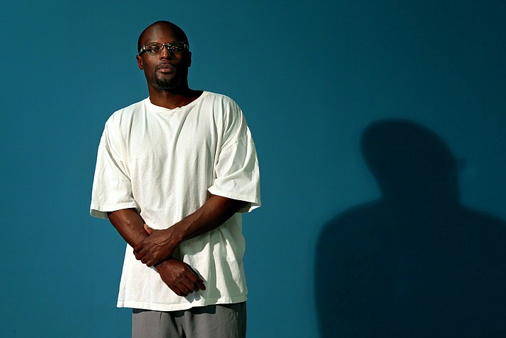 In this Thursday, July 10, 2014 photo, Bobby Bostic stands for a portrait in the visitation room at the Crossroads Correctional Center in Cameron, Mo., where he has served 23 years of a 241-year sentence for a 1995 robbery. At the age of 16, Bostic and a friend held up some people delivering some donated Christmas gifts to a needy St. Louis family. Bostic fired a shot that grazed one man. (Robert Cohen/St. Louis Post-Dispatch via AP)