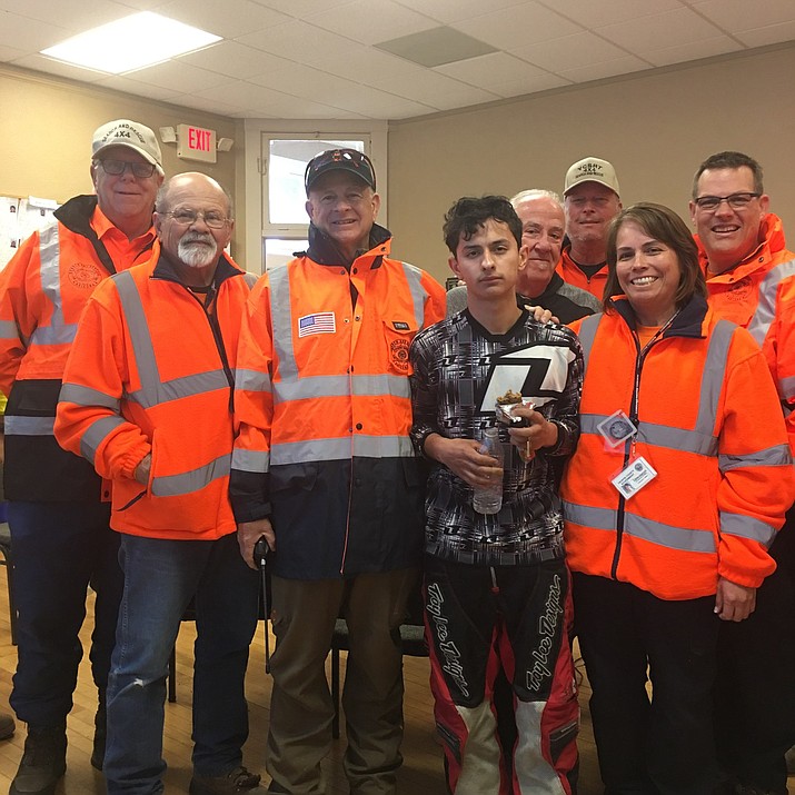 Jhon Zuluaga Ossa, 18, stands with members of the Yavapai County Search and Rescue Team after being found walking along Forest Road 362 near Crown King Monday morning, Jan. 21. The young man was riding an ATV in the area when he got lost and ran out of gas.