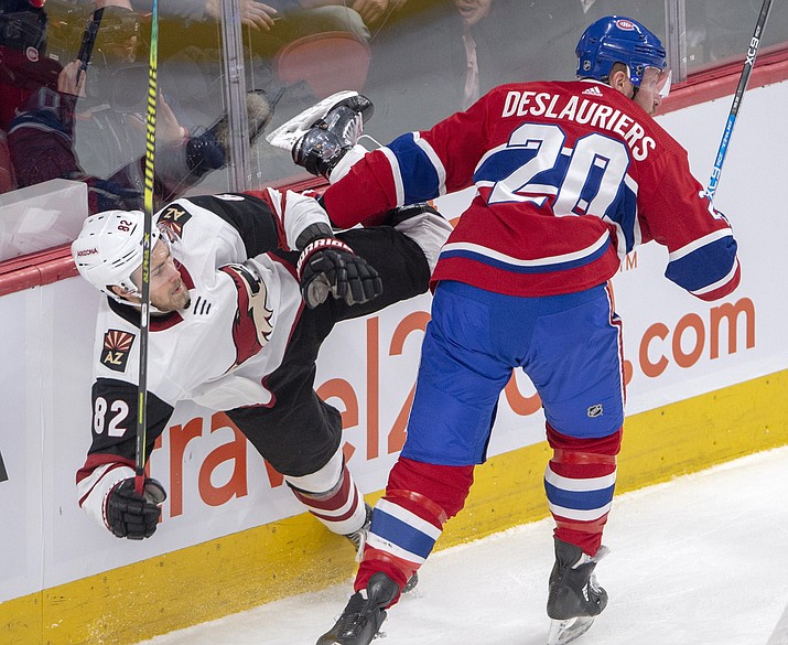 Arizona Coyotes defenseman Jordan Oesterle (82) is checked by Montreal Canadiens left wing Nicolas Deslauriers (20) during the first period of an NHL hockey game Wednesday, Jan. 23, 2019, in Montreal. (Ryan Remiorz/The Canadian Press via AP)