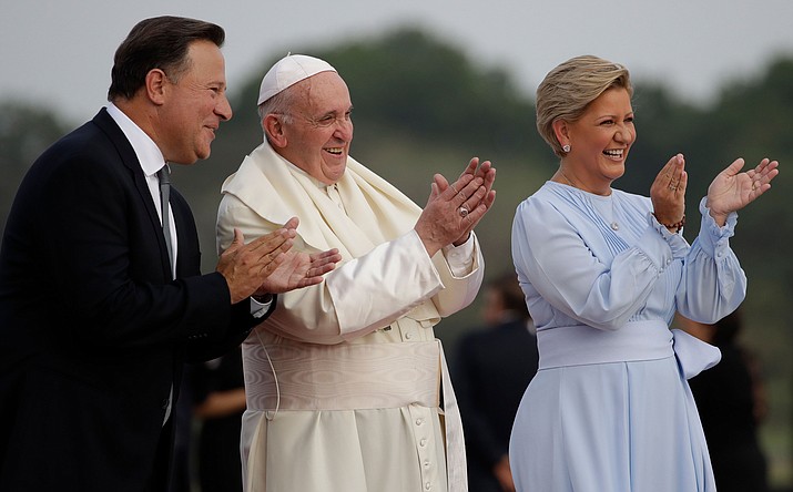 Pope Francis applauds children between Panamanian President Juan Carlos Varela and first lady Lorena Castillo de Varela after landing at Tocumen international airport in Panama City, Wednesday. Pope Francis will be in Panama Jan. 23-27 for World Youth Day events. (Alessandra Tarantino/AP)