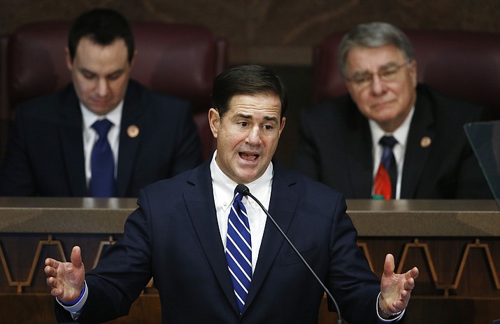 In this Jan. 8, 2018, file photo, Arizona Republican Gov. Doug Ducey, center, gives his state of the state address as he is flanked by House Speaker J.D. Mesnard, left, R-Chandler, and Senate President Steve Yarbrough, right, R-Chandler, at the capitol in Phoenix. Tax-filing season is just around the corner, but Arizona officials still don't know how they'll calculate your 2018 tax bill. That's because lawmakers punted last year on a routine vote to make the state and federal tax codes work together. (Ross D. Franklin/AP, file)