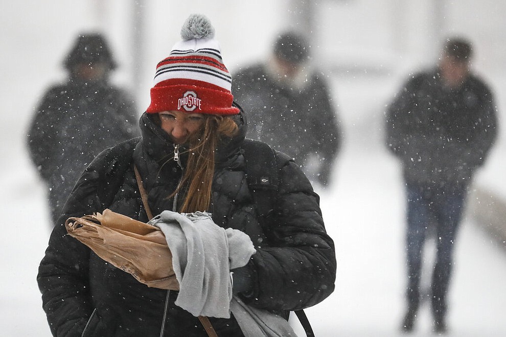 Commuters braves the wind and snow in frigid weather, Wednesday, Jan. 30, 2019, in Cincinnati. The extreme cold and record-breaking temperatures are crawling into a swath of states spanning from North Dakota to Missouri and into Ohio after a powerful snowstorm pounded the region earlier this week. (AP Photo/John Minchillo)