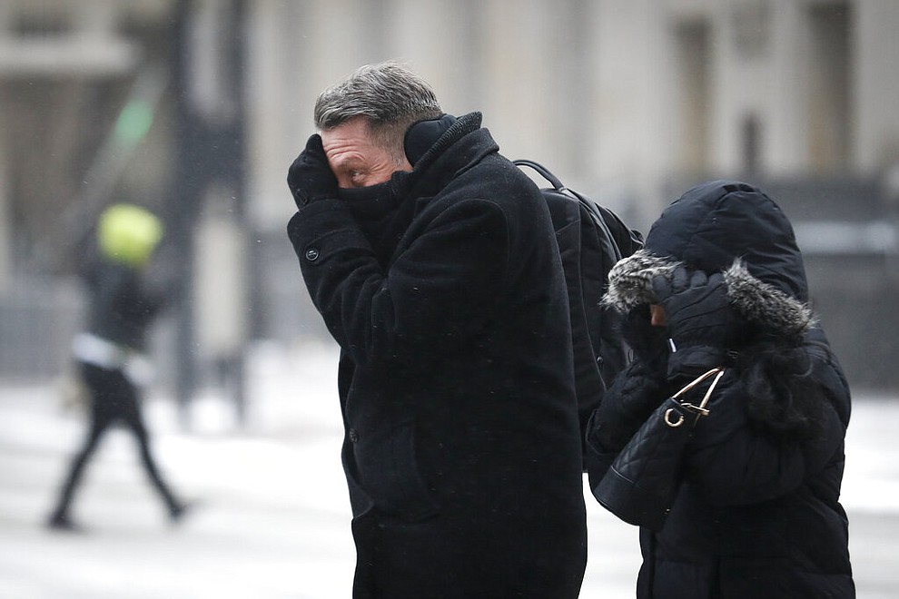 Commuters braves the wind and snow in frigid weather, Wednesday, Jan. 30, 2019, in Cincinnati. The extreme cold and record-breaking temperatures are crawling into a swath of states spanning from North Dakota to Missouri and into Ohio after a powerful snowstorm pounded the region earlier this week. (AP Photo/John Minchillo)