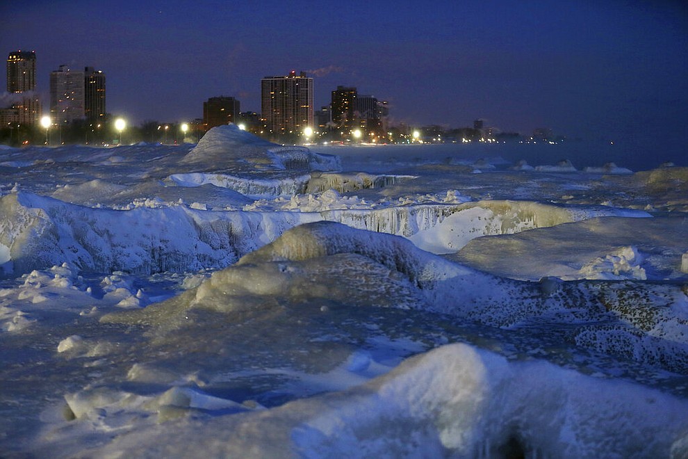 Ice forms along the shore of Lake Michigan before sunrise, Wednesday, Jan. 30, 2019, in Chicago. A deadly arctic deep freeze enveloped the Midwest with record-breaking temperatures on Wednesday, triggering widespread closures of schools and businesses, and prompting the U.S. Postal Service to take the rare step of suspending mail delivery to a wide swath of the region. (AP Photo/Kiichiro Sato)