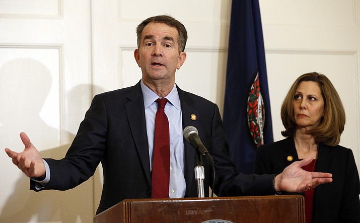 Virginia Gov. Ralph Northam, left, accompanied by his wife, Pam, speaks during a news conference in the Governor's Mansion in Richmond, Va., on Saturday, Feb. 2, 2019. Resisting widespread calls for his resignation, Northam on Saturday vowed to remain in office after disavowing a racist photograph that appeared under his name in his 1984 medical school yearbook. (AP Photo/Steve Helber)