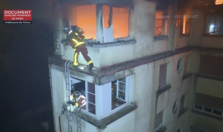 In this image taken from video released by the Paris Fire Dept., firemen scale the top floors of an apartment building on fire, Tuesday, Feb. 5, 2019, in Paris, France. A fire in a Paris apartment building has killed a number of people and sent residents fleeing to the roof or climbing out windows to escape. (Paris Fire Dept. via AP)