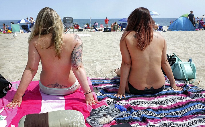 In this Aug. 26, 2017 file photo, women go topless as they participate in the Free the Nipple global movement during Go Topless Day at Hampton Beach, N.H. On Friday, Feb. 8, 2019, New Hampshire's highest court has upheld the conviction of three women arrested for going topless on a New Hampshire beach. In a 3-2 ruling, the court found Laconia's ordinance does not discriminate on the basis of gender or violate the women's right to free speech. (Ioanna Raptis/Portsmouth Herald seacoastonline.com via AP)