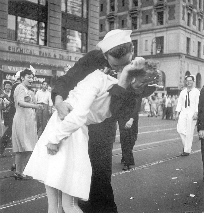 In this Aug. 14, 1945 file photo provided by the U.S. Navy, a sailor and a woman kiss in New York's Times Square, as people celebrate the end of World War II. The ecstatic sailor shown kissing a woman in Times Square celebrating the end of World War II has died. George Mendonsa was 95. This image was taken by U.S. Navy photographer Victor Jorgensen. The photo is of the same moment that photographer Alfred Eisenstaedt captured and first published in Life magazine. (Victor Jorgensen/U.S. Navy, File via AP)