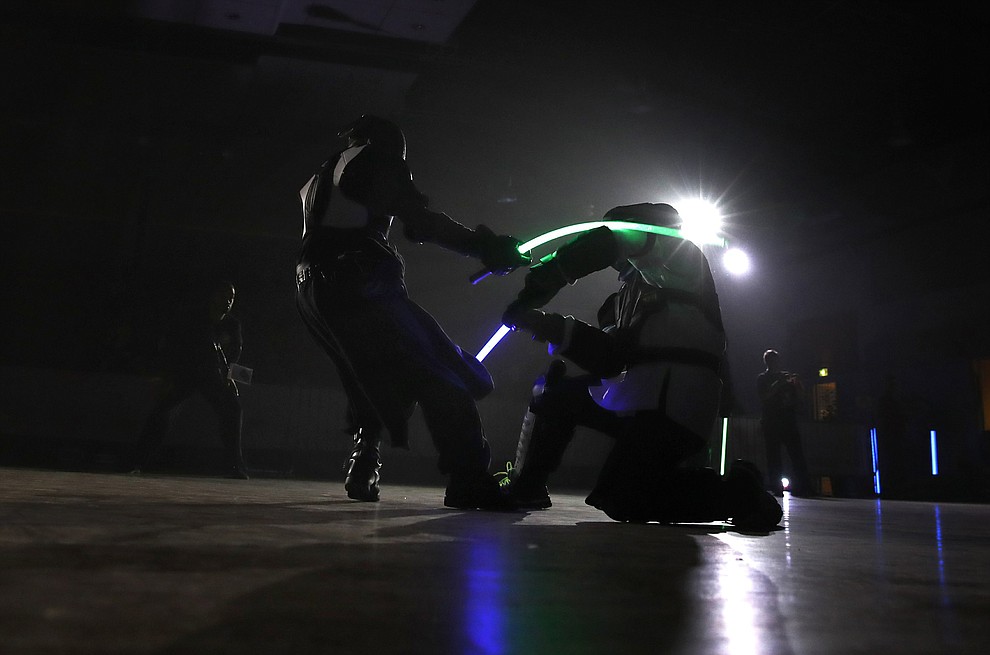 In this Sunday, Feb. 10, 2019, photo, competitors battle during a national lightsaber tournament in Beaumont-sur-Oise, north of Paris. (AP Photo/Christophe Ena)