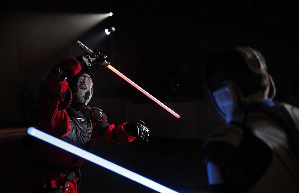 In this Sunday, Feb. 10, 2019, photo, Julien Esprit, left, competes with Jean Baptiste Marchetti-Waternaux during a national lightsaber tournament in Beaumont-sur-Oise, north of Paris. In France, it is easier than ever now to act out "Star Wars" fantasies. The fencing federation has officially recognized lightsaber dueling as a competitive sport. (AP Photo/Christophe Ena)