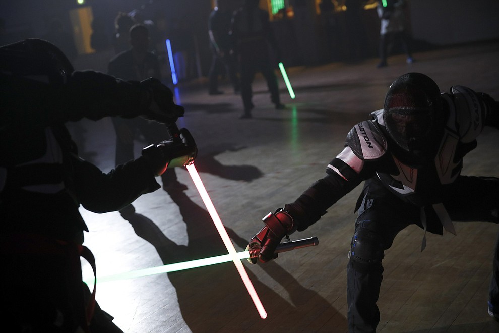 In this Sunday, Feb. 10, 2019, photo, competitors battle during a national lightsaber tournament in Beaumont-sur-Oise, north of Paris. "We wanted it to be safe, we wanted it to be umpired and, most of all, we wanted it to produce something visual that looks like the movies, because that is what people expect," said Michel Ortiz, the tournament organizer. (AP Photo/Christophe Ena)