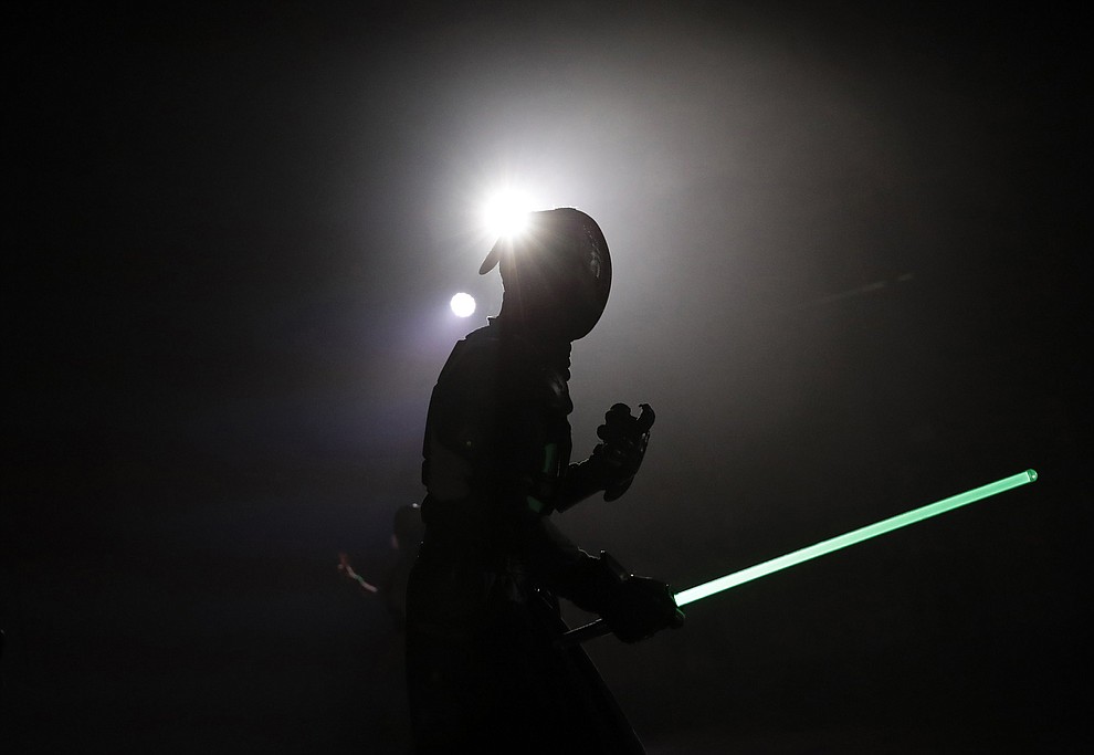 In this Sunday, Feb. 10, 2019, photo, a competitor battles during a national lightsaber tournament in Beaumont-sur-Oise, north of Paris. (AP Photo/Christophe Ena)