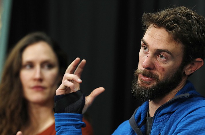 Travis Kauffman responds to questions during a news conference Feb. 14, in Fort Collins, Colorado, about his encounter with a mountain lion while running a trail just west of Fort Collins. Kaufman's girlfriend, Annie Bierbower, looks on. (AP Photo/David Zalubowski)