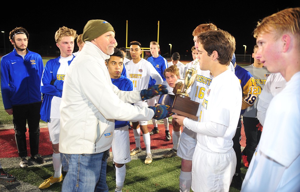 Dean Visser presents the runnerup trophy to Prescott's Nathaniel Koehler after the Badgers lost to the Salpointe Catholic Lancers in the Arizona Interscholastic Association 4A State Soccer Championship Tuesday, February 19, 2019 at Williams Field High School in Gilbert. (Les Stukenberg/Courier).