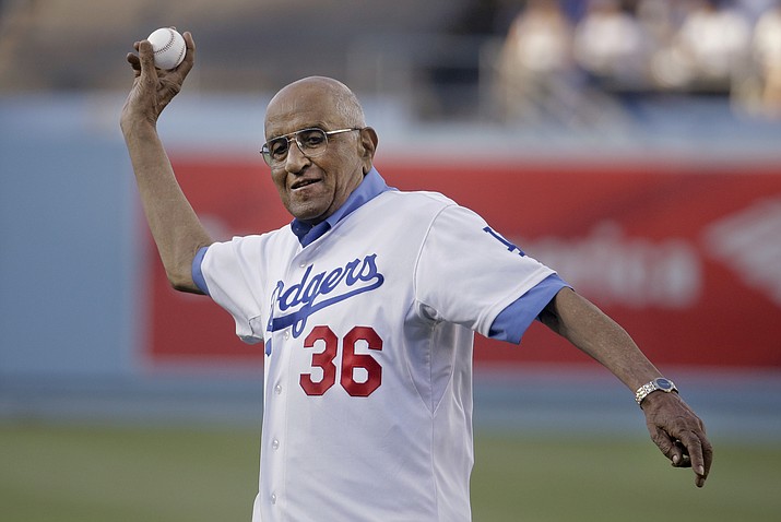 In this July 1, 2014, file photo, former Los Angeles Dodgers pitcher Don Newcombe throws a ceremonial pitch before a baseball game between the Los Angeles Dodgers and the Cleveland Indians, in Los Angeles. The team confirmed that Newcombe died Tuesday morning, Feb. 19, 2019, after a lengthy illness. (Chris Carlson/AP, file)
