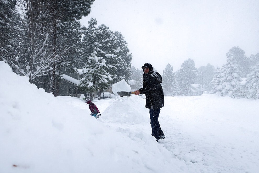 Morgan Baggs shovels the driveway at his home in Flagstaff, Arizona, on Thursday, Feb. 21, 2019. Schools across northern Arizona canceled classes and some government offices decided to close amid a winter storm that's expected to dump heavy snow in the region. (AP Photo/Felicia Fonseca)