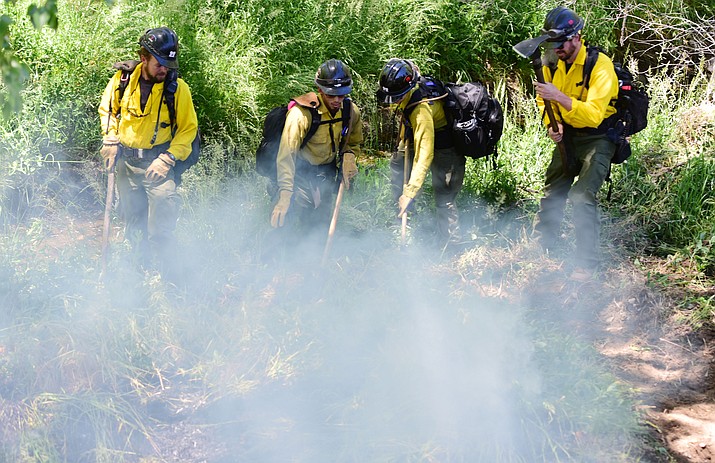 City of Prescott firefighters along with Prescott National Forest fire crews work a wild land fire in the Monument Park area near the Montezuma and Sheldon Street intersection on Tuesday, May 23, 2017.  (Les Stukenberg/Courier file)