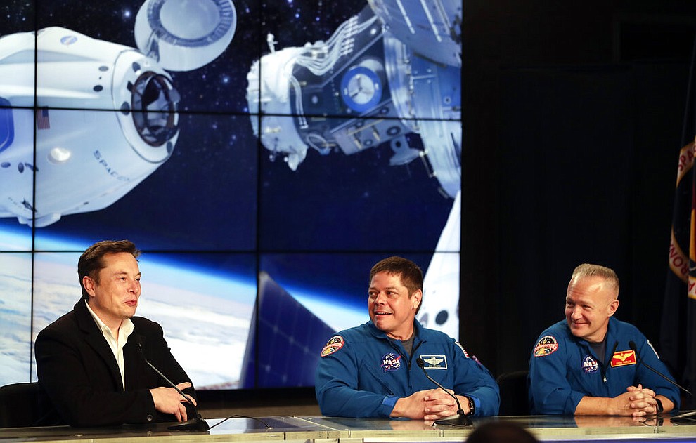 Elon Musk, left, CEO of SpaceX, speaks as NASA astronauts Bob Behnken, center, and Doug Hurley, right, listen during a news conference after the SpaceX Falcon 9 Demo-1 launch at the Kennedy Space Center in Cape Canaveral, Fla., Saturday, March 2, 2019. (AP Photo/John Raoux)