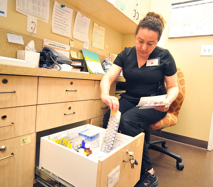 Alta Vista caregiver Lorena Chavez gets prescription drugs for a resident from a locked drawer in her office in Prescott on Tuesday, Feb. 27, 2019. (Les Stukenberg/Courier)